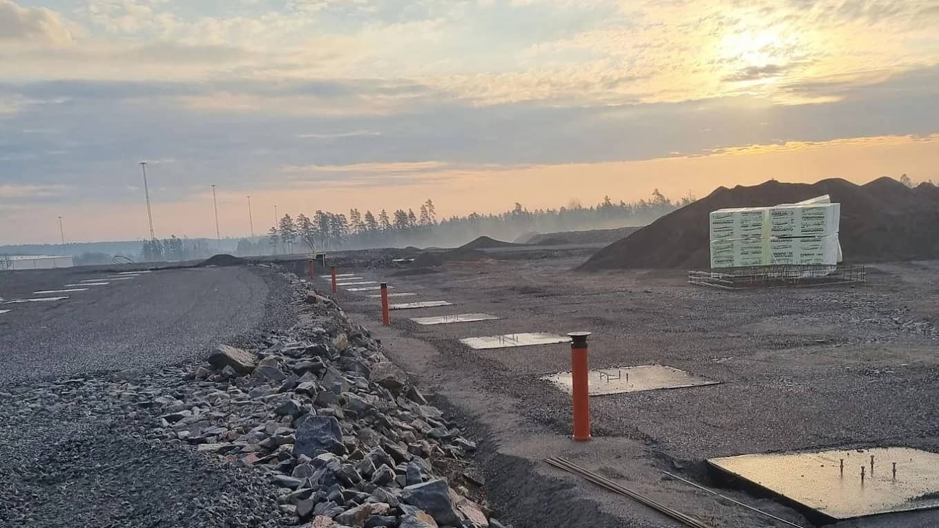 Markentreprenad i Örebro län – schaktad yta med bärlager, stenbank och gjutna fundament i soluppgång